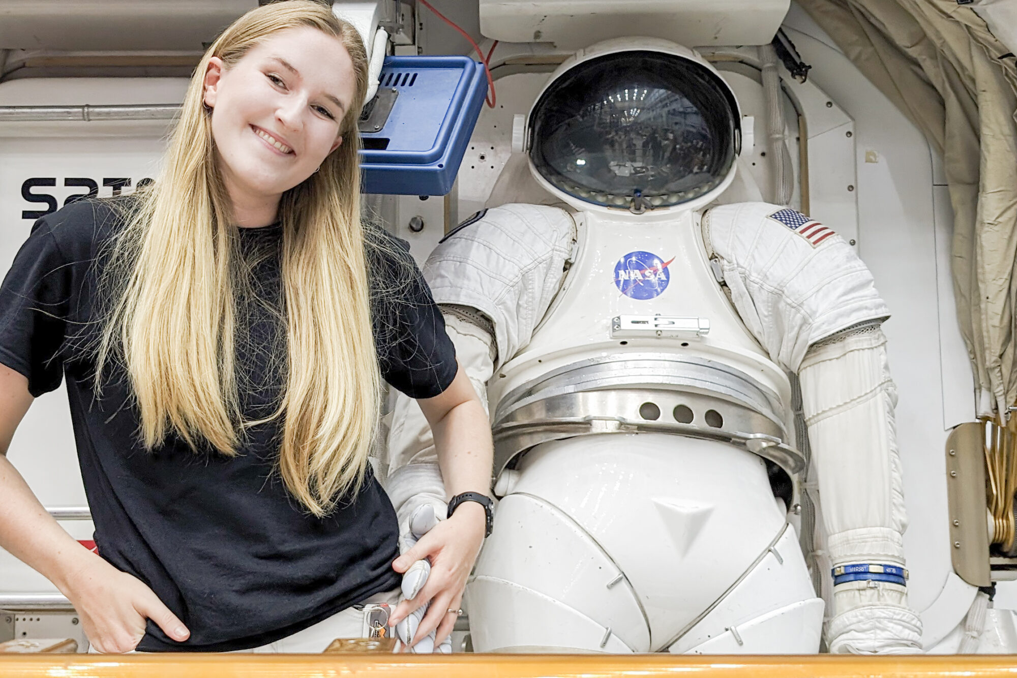Bildet viser en ung kvinne ved siden av en astronaut-dukke. Til artikkel om satellitter, romsøppel og romfart.