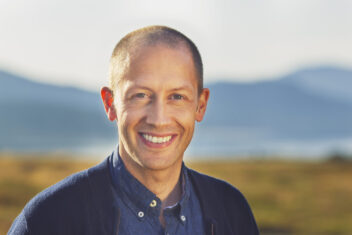 portrett av kortklipt mann med fjell i bakgrunnen. Bilde til sak om kunstig intelligens KI; strømforbruk og datasenter