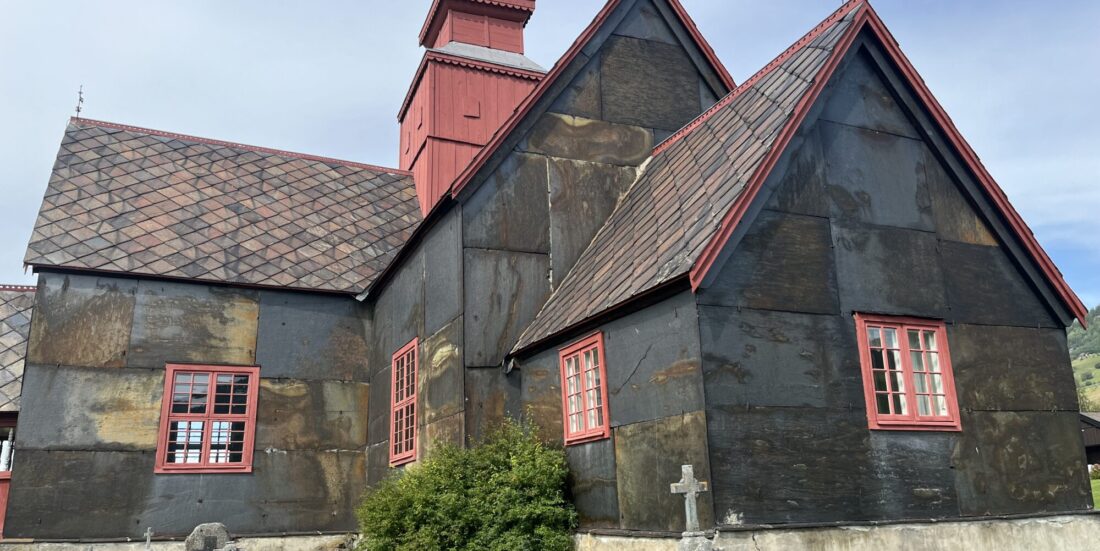 Dovre kirke, oppført som laftet korskirke 1736. Kirken fikk nytt tårn og skiferkledning på 1840-tallet. Skifertak og -kledning kan være over 180 år gammel. Her ser vi sørlig del med markant rustdannelse. Foto: Lisbet-Ingrid Alnæs