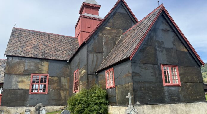 Dovre kirke, oppført som laftet korskirke 1736. Kirken fikk nytt tårn og skiferkledning på 1840-tallet. Skifertak og -kledning kan være over 180 år gammel. Her ser vi sørlig del med markant rustdannelse. Foto: Lisbet-Ingrid Alnæs