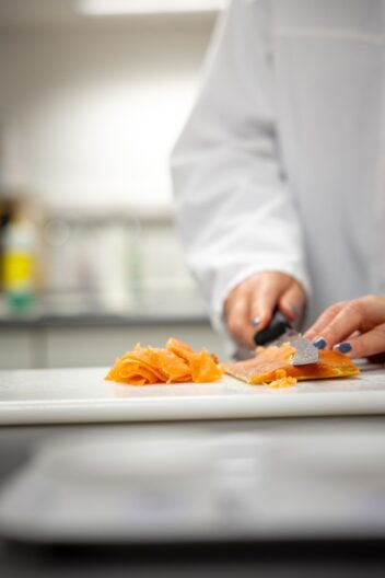 Røykaroma. Bildet viser Lene Waldenstrøms hender som kutter lakseskiver.