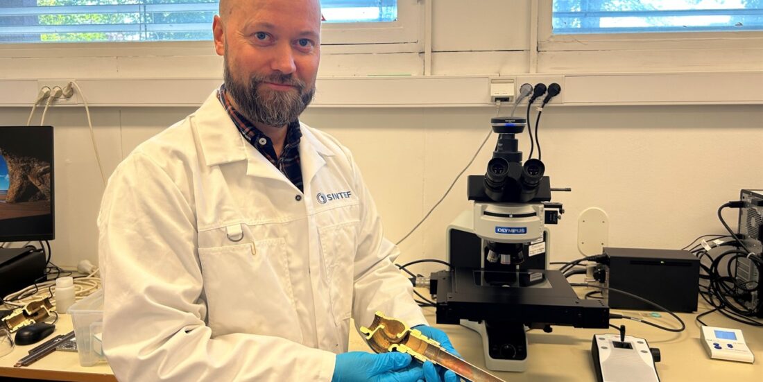 Ruben Lien Johansen i laboratoriet hos SINTEF. I hånden har han et vannrør i kobber.