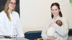 Foto av en kvinnelig lege og en mor med med baby på et legekontor.