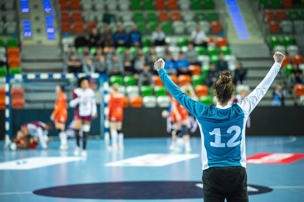 Bildet viser en spiller som jubler, med andre spillere i bakgrunnen.