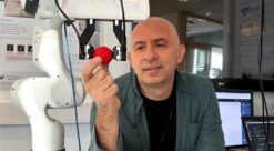 Forsker Ekrem Misimi i SINTEF viser fram roboten som kan "føle" som en menneskehånd. Her holder roboten et jordbær.