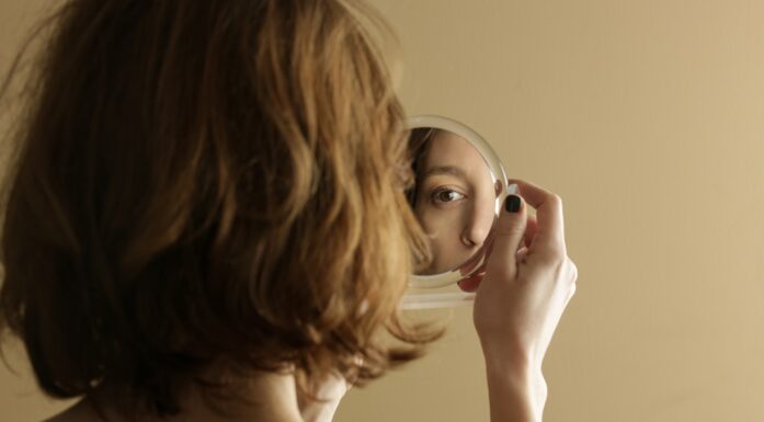 Tvang. Bildet viser en kvinne som ser seg i speilet.