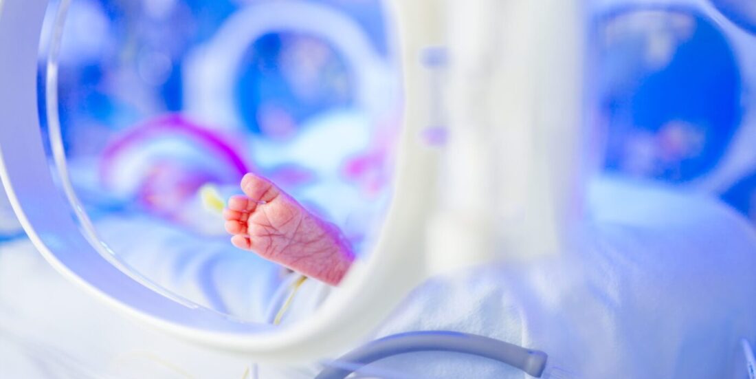 Foten til en liten baby i kuvøse.,