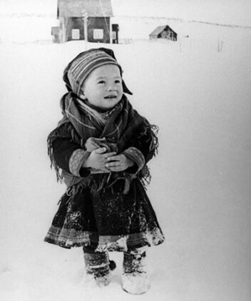 Foto av et samisk barn i snøen. 