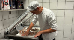 Kokk lager fiskekaker på produksjonskjøkkenet til Trondheim kommune.