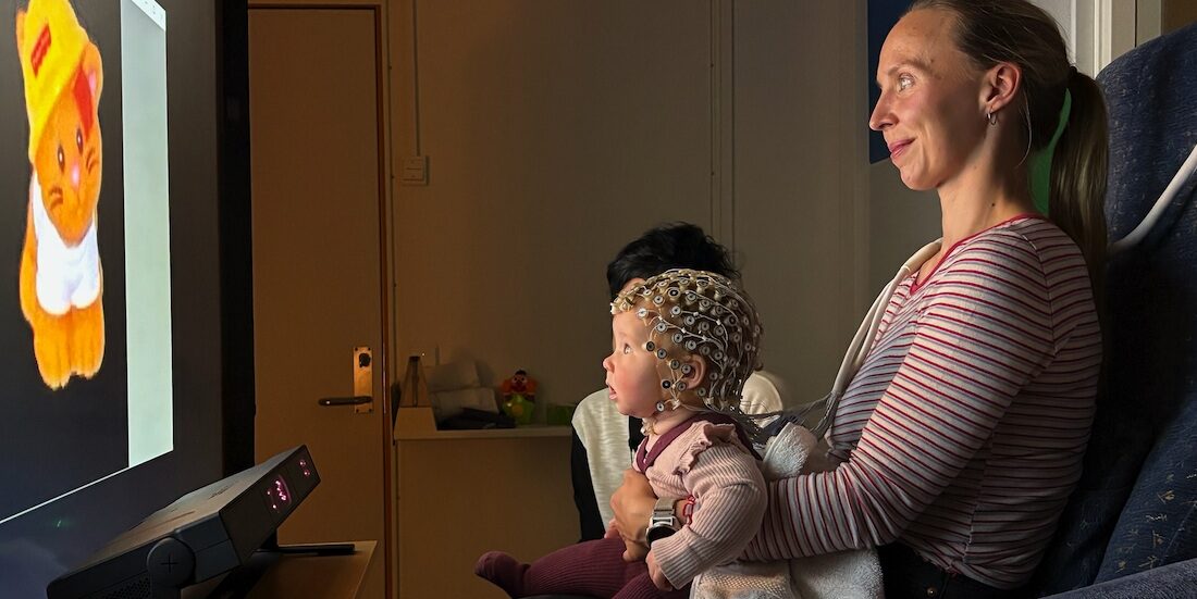 Bildet viser baby og mor foran en skjerm.