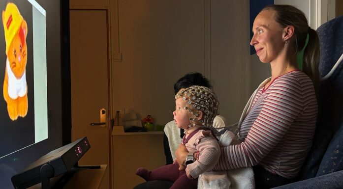 Bildet viser baby og mor foran en skjerm.