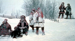 Foto av en gruppe samer i festdrakt ute i snøen.