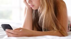Sexting. Bildet viser en jente som ligger på sengen med en mobiltelefon.