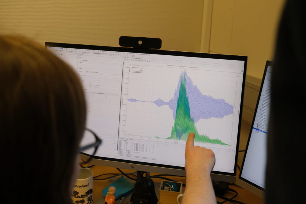 Forsker leser av graf som viser energien som finnes i ørsmå vibrasjoner. 