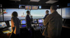 Bildet viser fire personer i en skipssimulator. Det illustrerer en artikkel om sjøfolk og selvkjørende skip