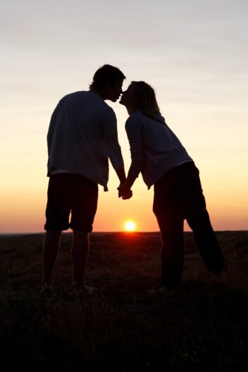 Forhold. Bildet viser en silhuett av et par i solnedgangen.