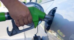 Bensin. Bildet viser en hånd som tanker opp bilen med en bensinpumpe.