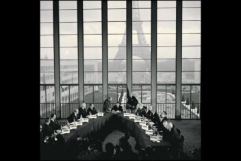 Bildet viser representante fra NATO-land foran et vindu der Eiffeltårnet vises i bakgrunnen.