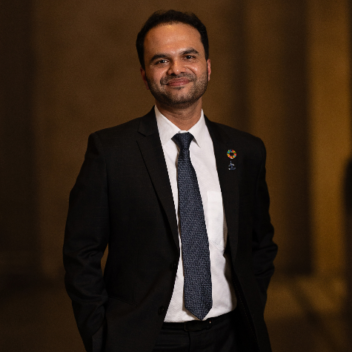 Ung mann med mørk dress og slips. Bilde til artikkel om vindturbinblader og bærekraft. 