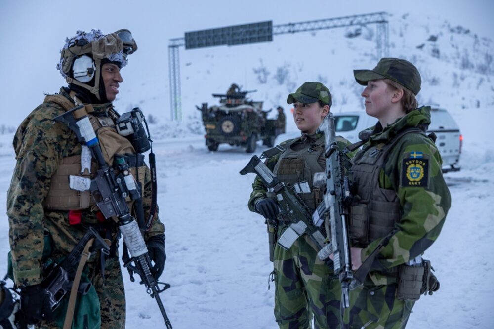 NATO. Bildet viser en soldat fra US Marines som snakker med to svenske soldater.