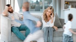 Hjernen. Bildet viser to utslitte foreldre i sofaen mens to barn herjer rundt.