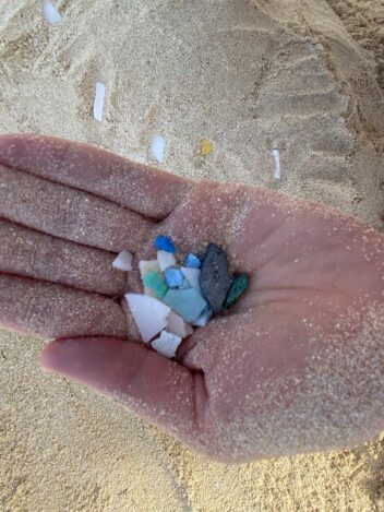 Bildet viser ei hånd med plastbiter i.