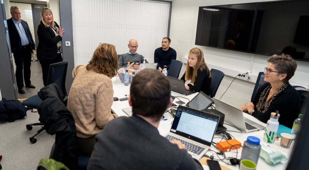 Cyberangrep. En rekke mennesker er samlet rundt et bord.