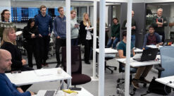 Cyberangrep. En rekke ansatte og studenter er samlet i et rom med flere hvite pulter.