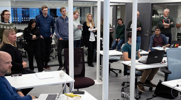 Cyberangrep. En rekke ansatte og studenter er samlet i et rom med flere hvite pulter.