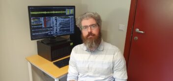 David WIlliamson foran en dataskjerm.