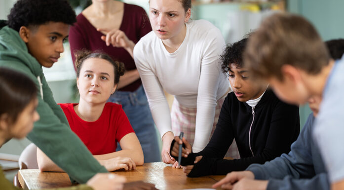 Seks ungdommer diskuterer sammen i et klasserom. Foto.