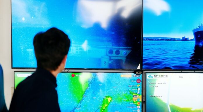Bildet er hentet fra Norsk havteknologisenter, og viser en person foran en rekke skjermen med bilder fra skipsfart og havbunn.