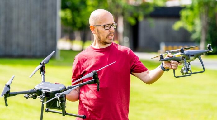 Droner. Ken Hellerud med to droner utendørs.