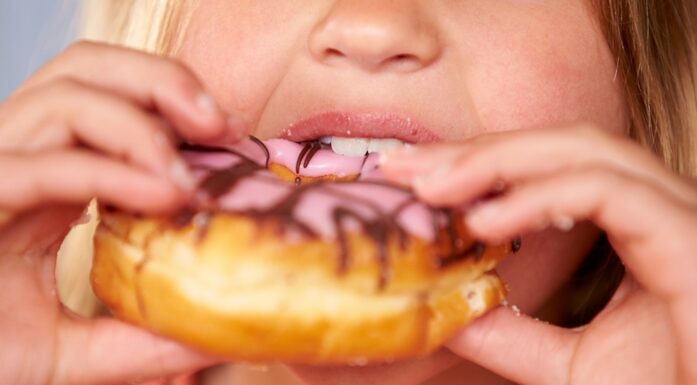 Ei jente spiser en donut.